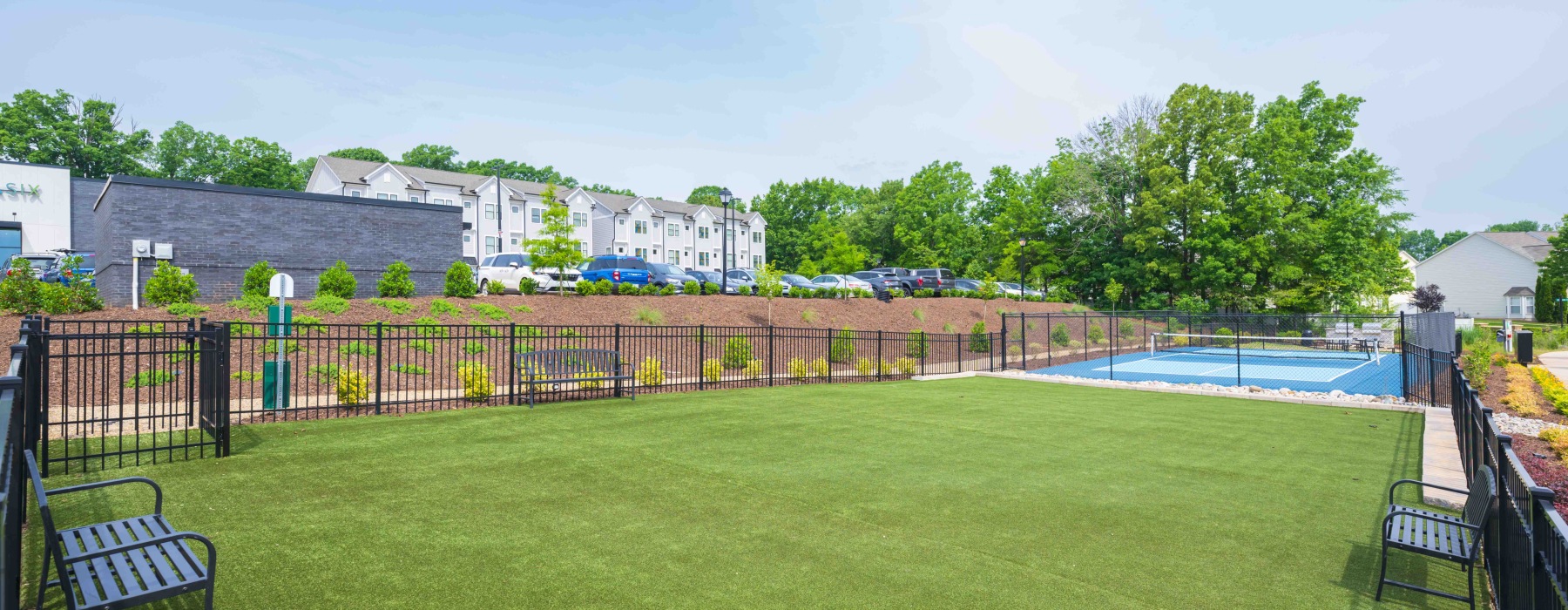 fenced green space with seating and lawn area in Highland Creek Charlotte townhome community